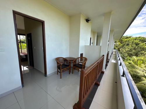 a balcony of a house with a table and chairs at Brata Cottage Ubud in Ubud