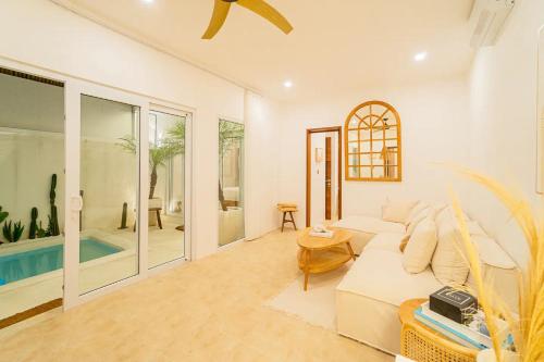 sala de estar con sofá blanco y piscina en Kokomo Villas by Aayan, en Canggu