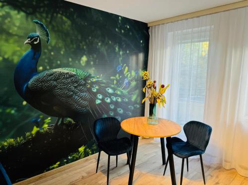 a dining room with a large peacock mural on the wall at Blue Apartment close to Old Town in Bydgoszcz