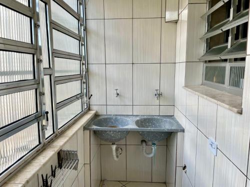 a bathroom with a sink in a room at Apartamento aconchegante no Centro de Peruibe in Peruíbe
