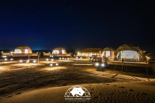 a group of tents in the desert at night at Sahara Dome Camp in Merzouga
