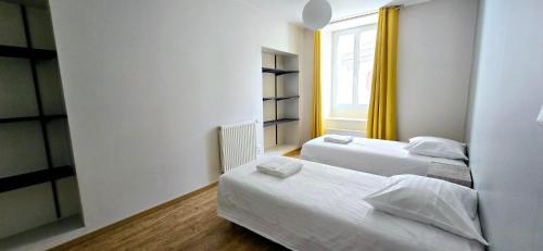 une chambre avec deux lits et une fenêtre dans l'établissement Le Tandem, à Thonon-les-Bains