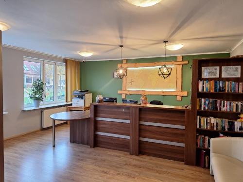 a library with a desk and a book shelf at Politechnika Warszawska Ośrodek Wypoczynkowy in Sarbinowo