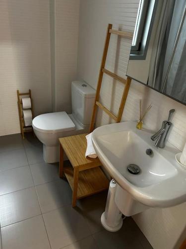 a bathroom with a sink and a toilet and a mirror at Malpica beach in Malpica
