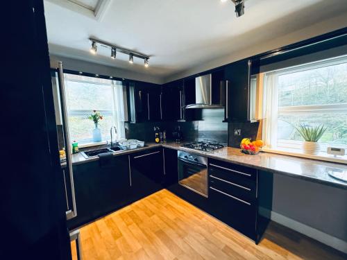 a kitchen with black cabinets and a window at New Road Apartment - 2 Bedrooms - Sleeps 3 in Whitehaven