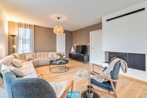 a living room with a couch and a table at Villa Sailing-large luxury house in quiet location in Nieuwpoort