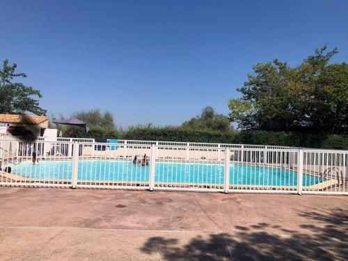 une clôture blanche autour d'une piscine dans l'établissement Villa Playa proche plage piscine climatisation parking, à Palavas-les-Flots