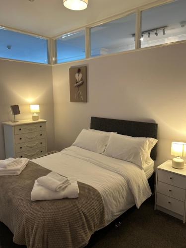a bedroom with a large bed and two night stands at 10 Thurnams House in Carlisle