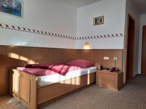 a bedroom with a bed with a wooden headboard at Pension Schwaiger in Bad Gögging