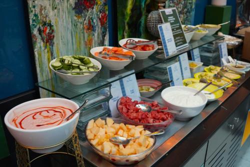 a buffet filled with bowls of fruit and vegetables at FORTUNE ATRIUM HOTEL in Dubai