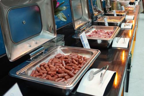 a buffet line with trays of food on display at FORTUNE ATRIUM HOTEL in Dubai