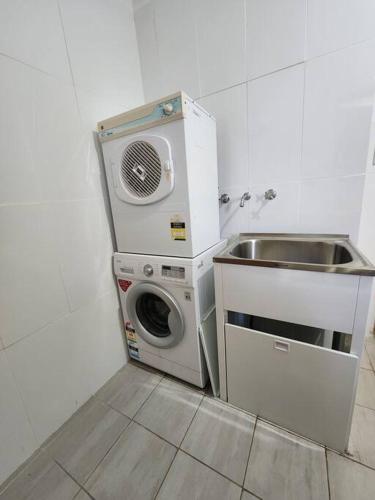 a kitchen with a washing machine and a sink at The O'Bryan Cottage in Burra