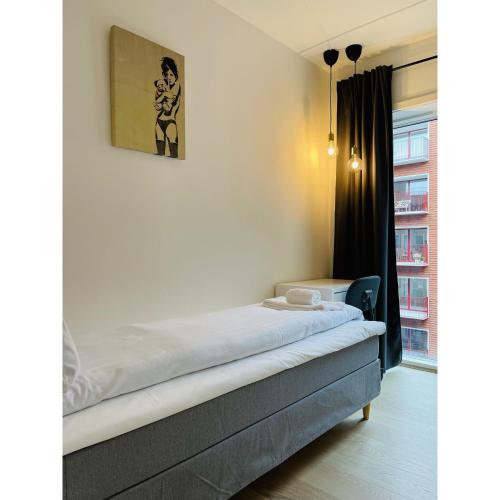 a bed in a room with a picture on the wall at ApartmentInCopenhagen Apartment 1463 in Copenhagen