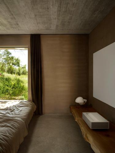 a bedroom with a bed and a large window at Cá na Serra in Melides