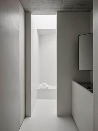 a living room with a television and a white wall at Cá na Serra in Melides