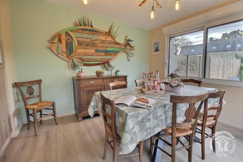 une salle à manger avec une table et un poisson sur le mur dans l'établissement Ty palus, à Plouha
