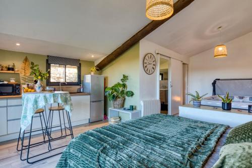 une chambre avec un grand lit et une cuisine dans l'établissement Chambre spa privé Arles campagne, à Arles