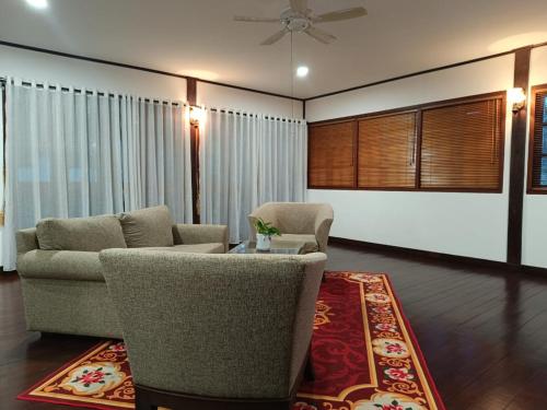 a living room with a couch and chairs and a rug at Nongsa Village in Nongsa