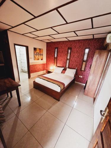 a bedroom with a bed and a red wall at Manjuwele Lodge in Limbe