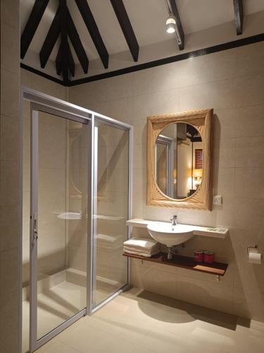 a bathroom with a shower and a sink and a mirror at Nongsa Village in Nongsa