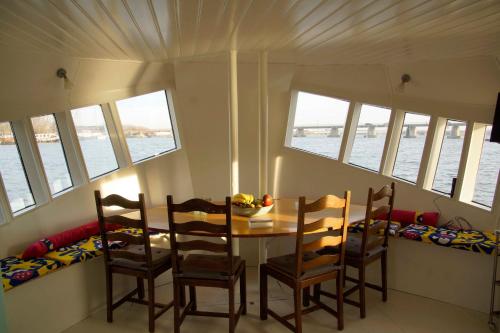 a dining room with a table and chairs and the water at The Island Houseboat in Amsterdam
