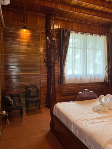 a bedroom with a bed and a window at ห้างหุ้นส่วนจำกัด บ้านเถ้าแก่ in Ban Muang Baeng