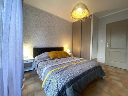 une chambre avec un lit et un lustre dans l'établissement #Aillan Hervé #Maison avec piscine privée en provence, à Saint-Maurice-sur-Eygues