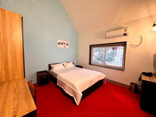 a bedroom with a large bed and a window at Ariana Homestay in Siliguri