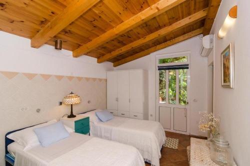ムリニにあるOldstyle Villa with a Seasonal Poolの木製の天井の部屋にベッドが2つある