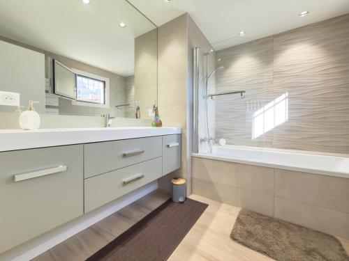 une salle de bain avec un lavabo, une baignoire et une douche dans l'établissement Le Marcellin by Winsome Destination, à Cannes