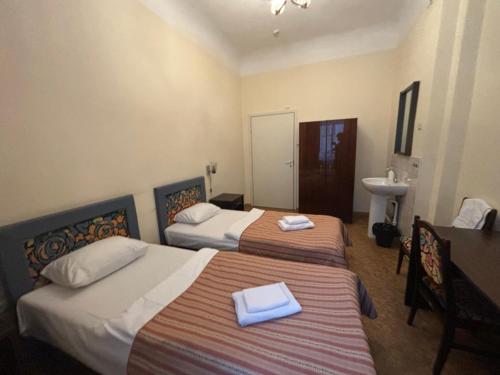 a hotel room with two beds and a sink at Hostel Viktorija with Private Rooms in Rīga