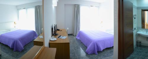 a hotel room with two beds and a sink at Vea Resort Hotel in Mercato San Severino