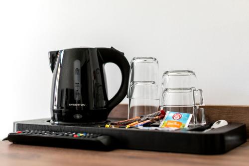 a coffee maker and two glasses on a table at Cooltour Hostel in Poznań
