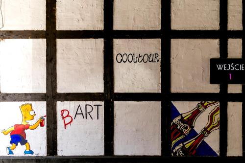 a wall with graffiti on the side of it at Cooltour Hostel in Poznań