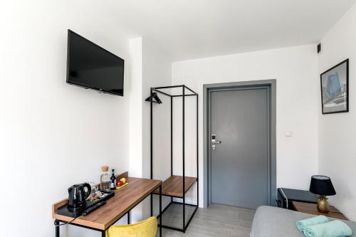 a living room with a table and a tv on a wall at Cooltour Hostel in Poznań