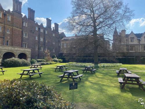 a group of picnic tables in front of a building at Sidney Sussex College, Cambridge in Cambridge