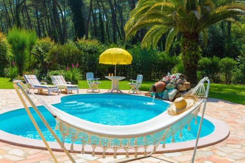 - une piscine avec un hamac, des chaises et une table dans l'établissement Villa charmante 3 étoiles à Biarritz Anglet, piscine privée et jardin., à Anglet