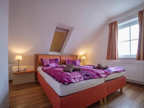 a bedroom with a large bed with purple sheets at Ferienhäuser Greetsiel - Urlaub mit Haustier in Ostfriesland in Greetsiel