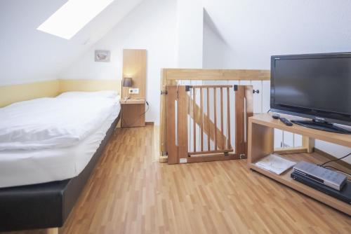 a bedroom with a bed and a flat screen tv at Ferienhäuser Greetsiel - Urlaub mit Haustier in Ostfriesland in Greetsiel