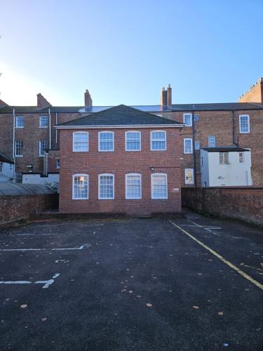 an empty parking lot in front of a brick building at Quiet Location near the Docks secure parking x2 in Gloucester