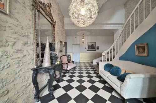 un salon avec un escalier et un lustre dans l'établissement Château de Fajac la Selve, à Pech-Luna