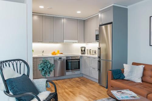 a living room with a couch and a kitchen at Forenom Serviced Apartments Helsinki Töölö in Helsinki