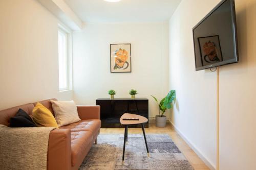 a living room with a couch and a tv on a wall at Forenom Serviced Apartments Helsinki Töölö in Helsinki