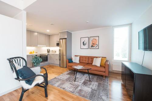 a living room with a couch and a table at Forenom Serviced Apartments Helsinki Töölö in Helsinki