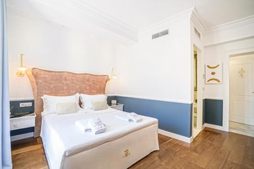 a bedroom with a white bed and a blue wall at Casa Kallergi in Chania Town