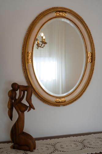a mirror on a wall next to a wooden statue at La Tartaruga in Siena