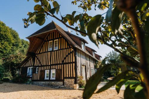 une vieille maison avec un toit à la mansarde dans l'établissement Colombe - Une Maison du Pays d'Auge - Bain nordique 9P, à Le Mesnil-Eudes