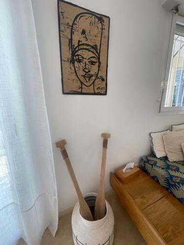 a room with two wooden baseball bats in a vase at Agence Adjana Resort - Résidence du Port 3 in Sali Tapé