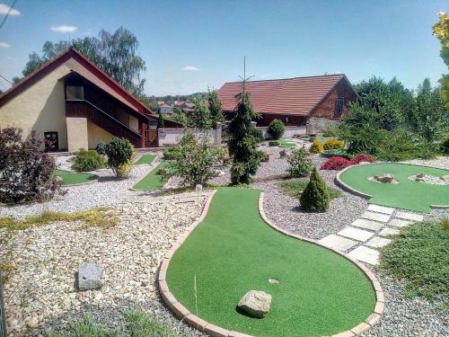 a garden with a miniature golf course in front of a house at Penzion Na Majlantě in Miřetice