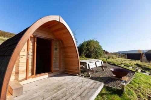 a wooden gazebo with a table and a grill at Kennacoil in Dunkeld